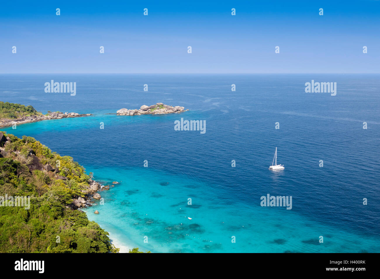Tropical island surrounded by transparent turquoise water and coral reefs Stock Photo