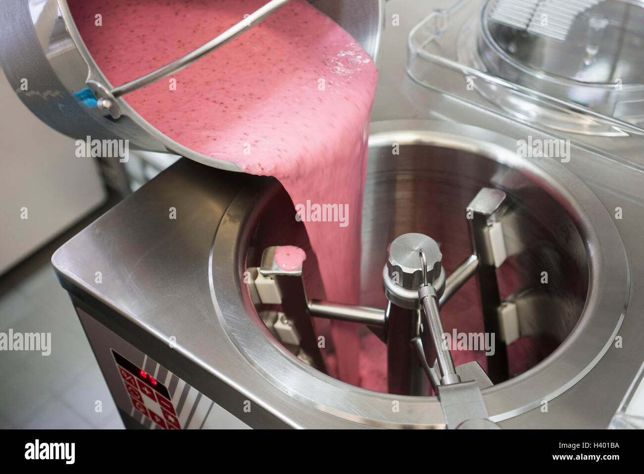 Pink mixture pouring in ice cream maker at store Stock Photo Alamy