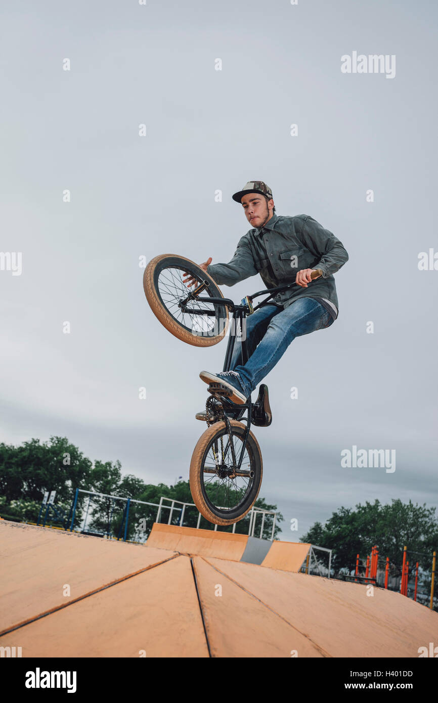 Teenager performing stunt at skateboard park against sky Stock Photo