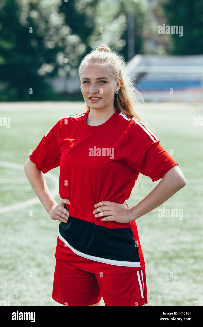 Confident soccer player standing with hands on hip on field Stock Photo