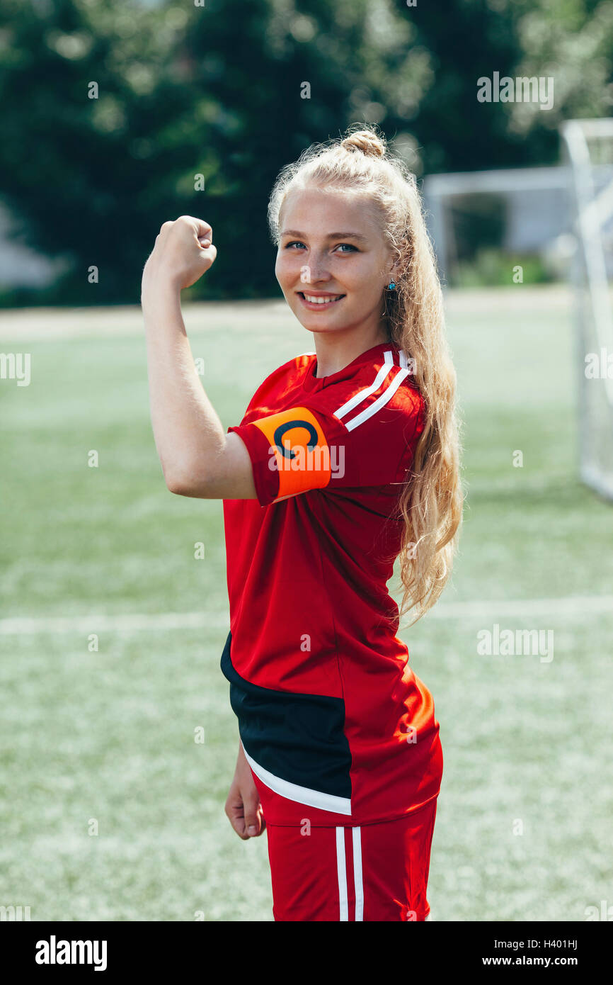 Confident soccer captain showing band with letter C on field Stock Photo