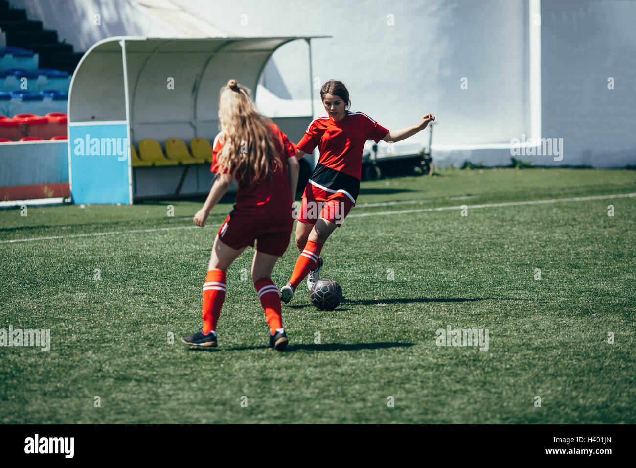 Determined teenagers playing soccer on field Stock Photo