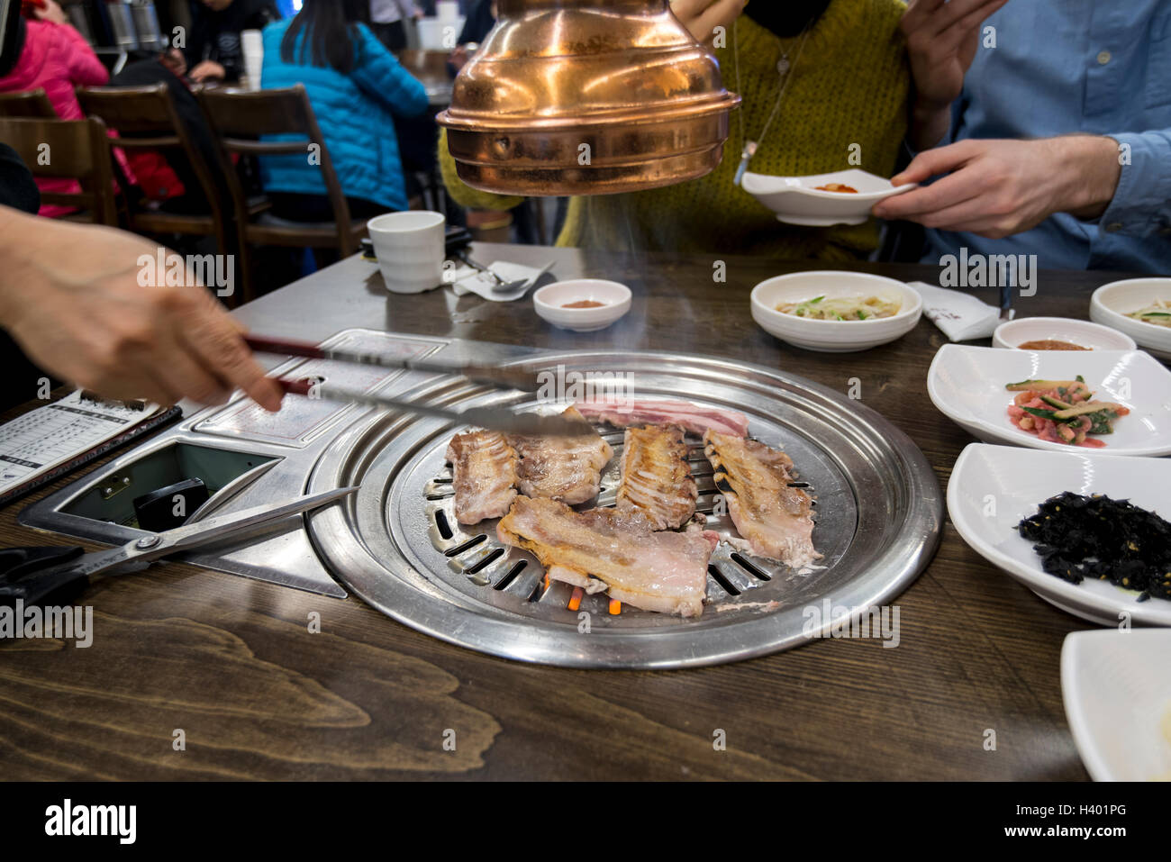Cooking meat the table grill in a Korean BBQ restaurant, Seoul, Korea Stock Photo - Alamy