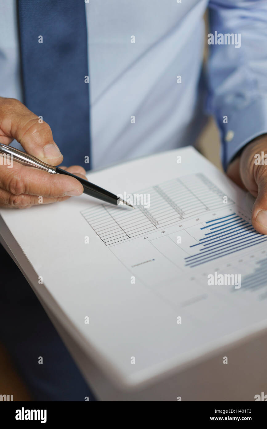 Graph Paper Person Midsection of businessman analyzing graph papers Stock Photo - Alamy