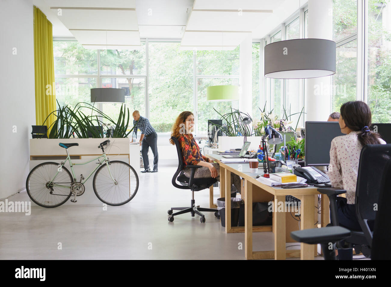 Business people working in brightly lit creative office Stock Photo