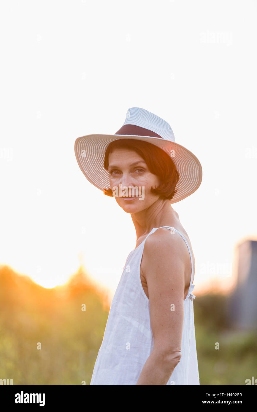 Portrait of confident woman wearing hat standing against clear sky Stock Photo