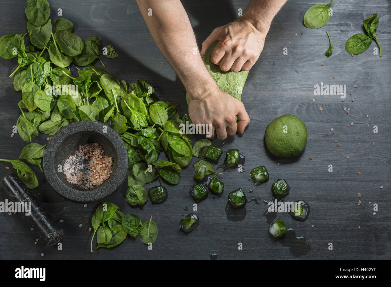 https://c8.alamy.com/comp/H402YT/cropped-image-of-hands-kneading-green-dough-by-basil-ice-cubes-at-H402YT.jpg