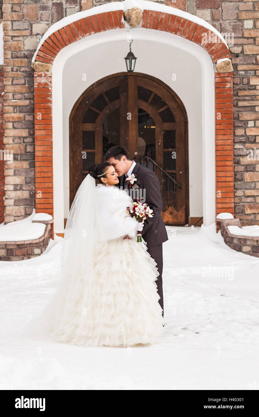 Romantic kiss happy bride and groom on winter wedding day Stock Photo ...