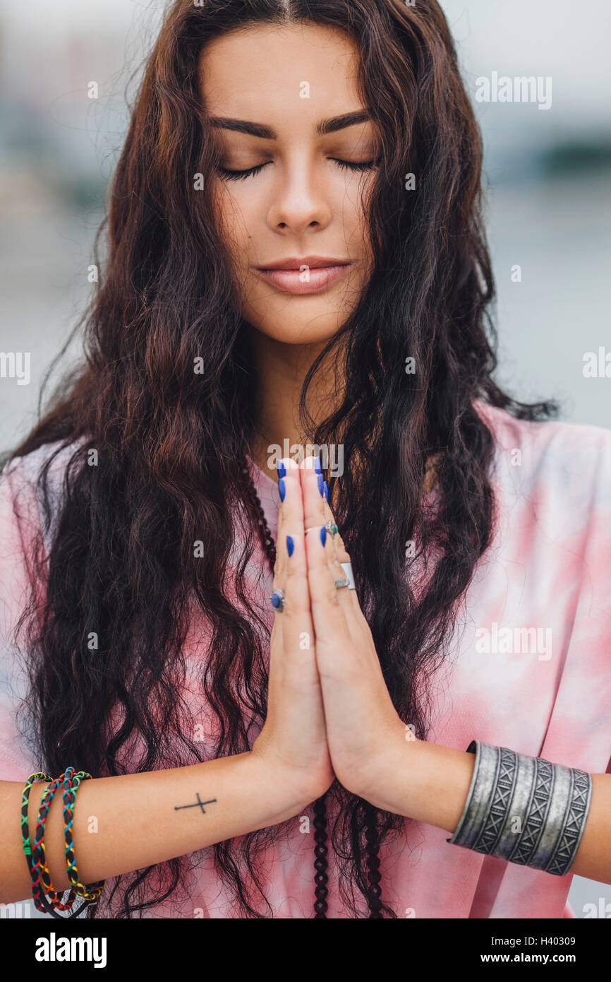 Young woman with closed eyes practicing yoga in prayer position Stock Photo