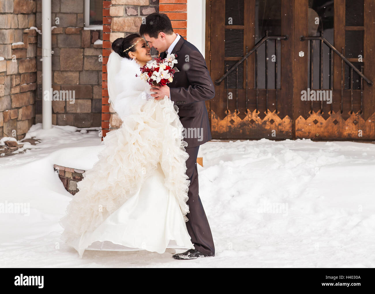 Romantic kiss happy bride and groom on winter wedding day Stock Photo ...