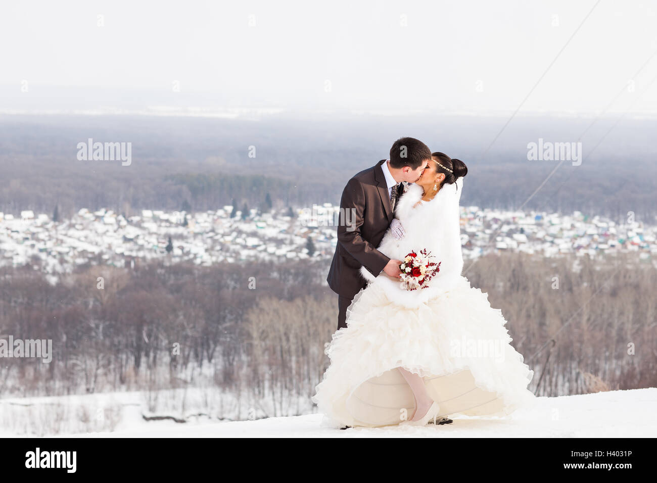 Romantic kiss happy bride and groom on winter wedding day Stock Photo ...