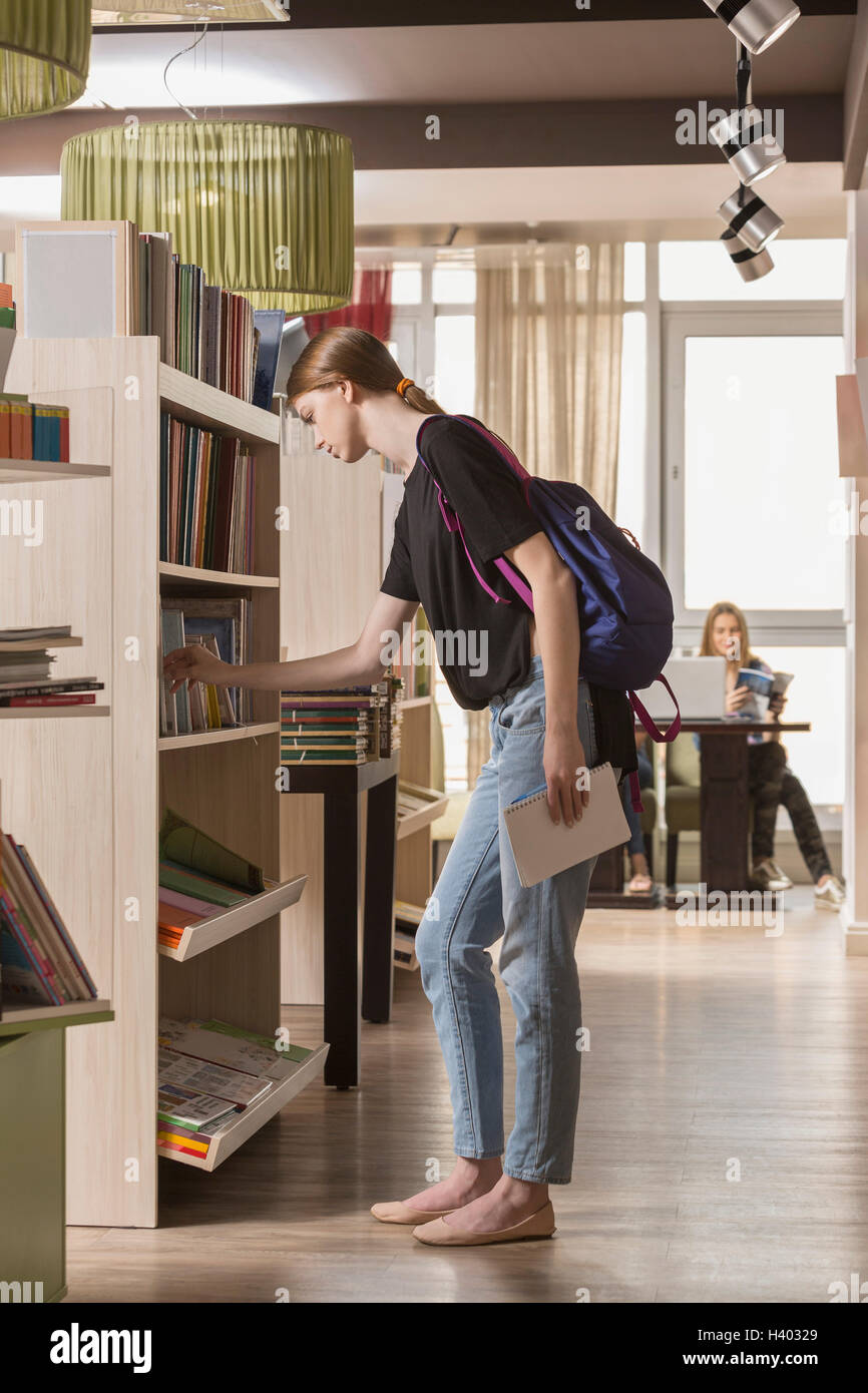 Side view of woman searching for book at library Stock Photo