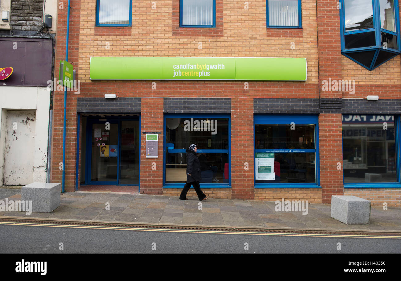 A woman walks passed a job centre in Blackwood, South Wales. Stock Photo