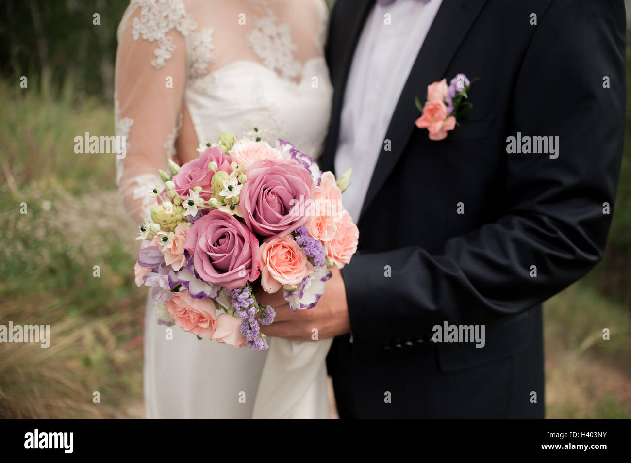 wedding couple hugging, the bride holding a bouquet of flowers in her ...