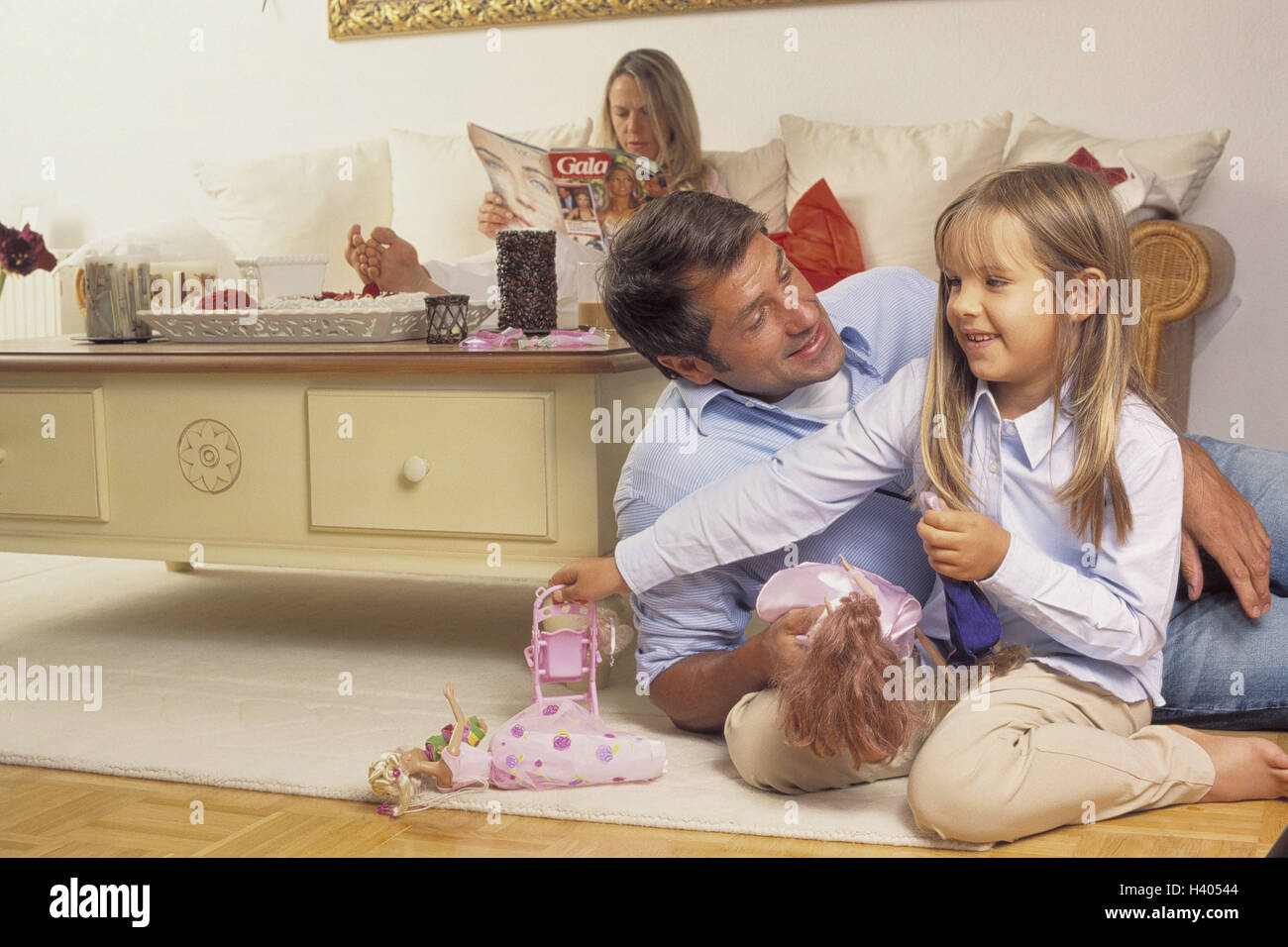 Sitting rooms, father, subsidiary, play, Barbiepuppen, nut, magazine, read,  leisure time, family, man, child, girl, dolls, Barbie, Barbies,  Barbiepuppe, game, together, floor, happy, allowance, care, harmony, woman,  sofa, magazine, magazine, family life
