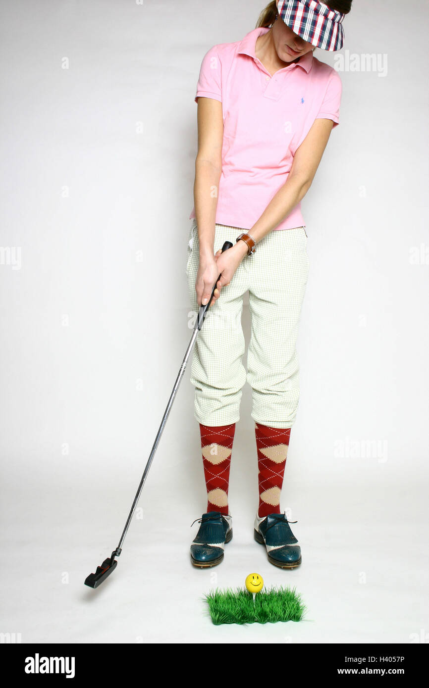 Golfer, young, golf clubs, art lawns,,  Tea, golf ball, Smiley  Series, woman, golfer, concentration, intently, 20 - 30 years, lawns, art grass, grass, artificially, ball, mini golf, reduction, locking up, lawn surface, Indoor, T, sport, golf, golf game, gulves, practicing, training, golf training, golf shoes, shoes, stockings, socks, checkered, stockings, knee association pants, clothing, Golfstyle, golf kit, golf fashion, sun sign, Pattern, face, smiles, cleverly, kindly, childishly, concept, studio, broached Stock Photo