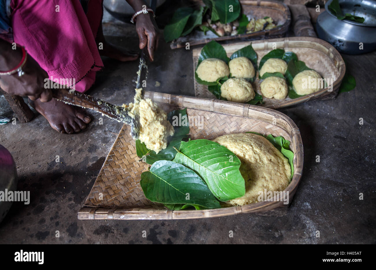 An indigenous Adivasi woman prepares millet cake on a leaf plate in Jharkhand, India. Stock Photo