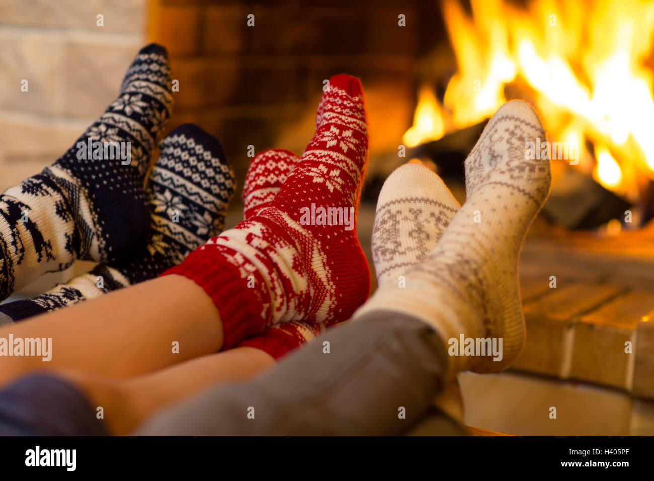 Family in socks near fireplace in winter or christmas time Stock Photo