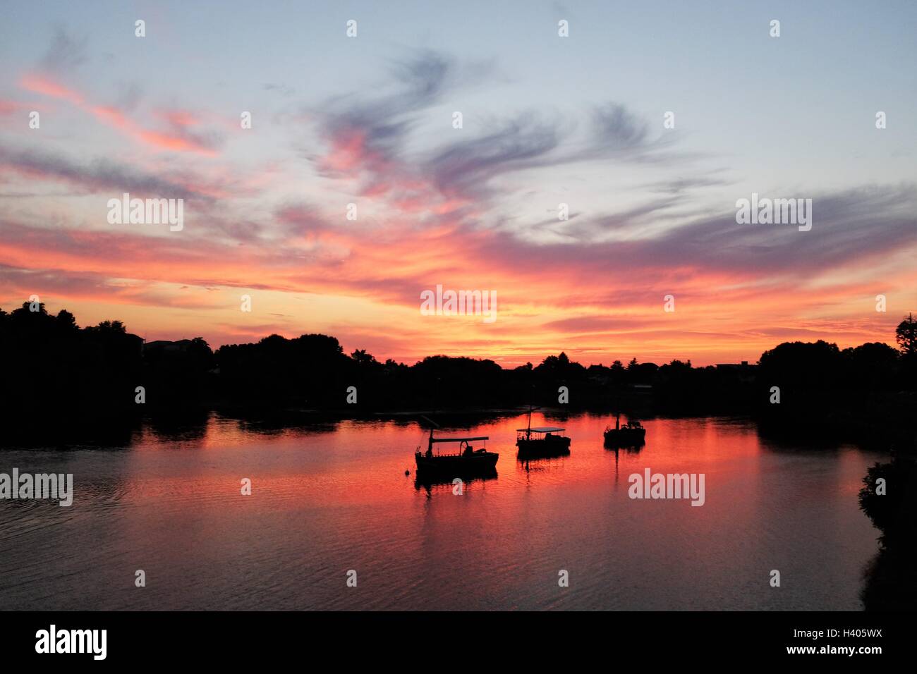 Silhouette of boats on Dordogne river at sunset, Bergerac, France Stock Photo