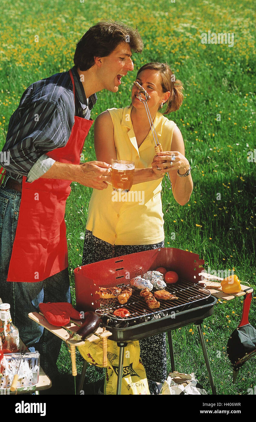 Meadow, couple, barbecue, grill small sausage, try, happily, garden grill, charcoal grill, food, prepare, cook, eat, food, meat, grill meat, sausages, leisure time, fun, together, beer glass, drink, enjoys, outside Stock Photo