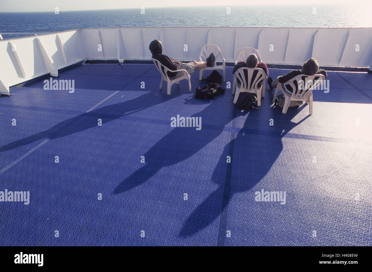 Ferry, solar cap, passengers, the suns, back view, sea, ship, car ferry, navigation, transport, promotion, cruise, deck, chairs, travellers, tourists, recreation, rest, enjoy, take it easy, leisure time, vacation Stock Photo