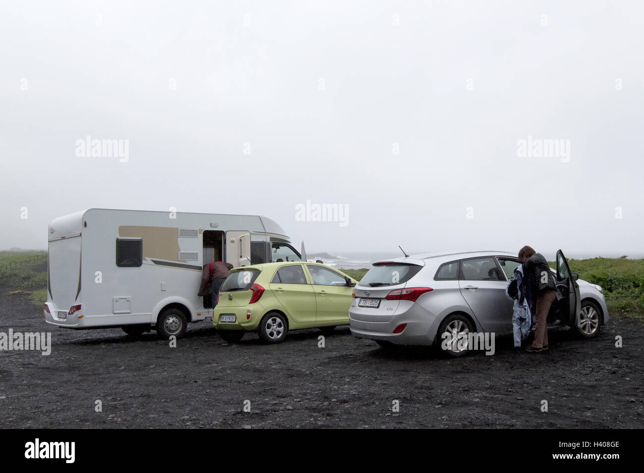 tourists park in car park near black sand beach in bad weather Vik Iceland Stock Photo