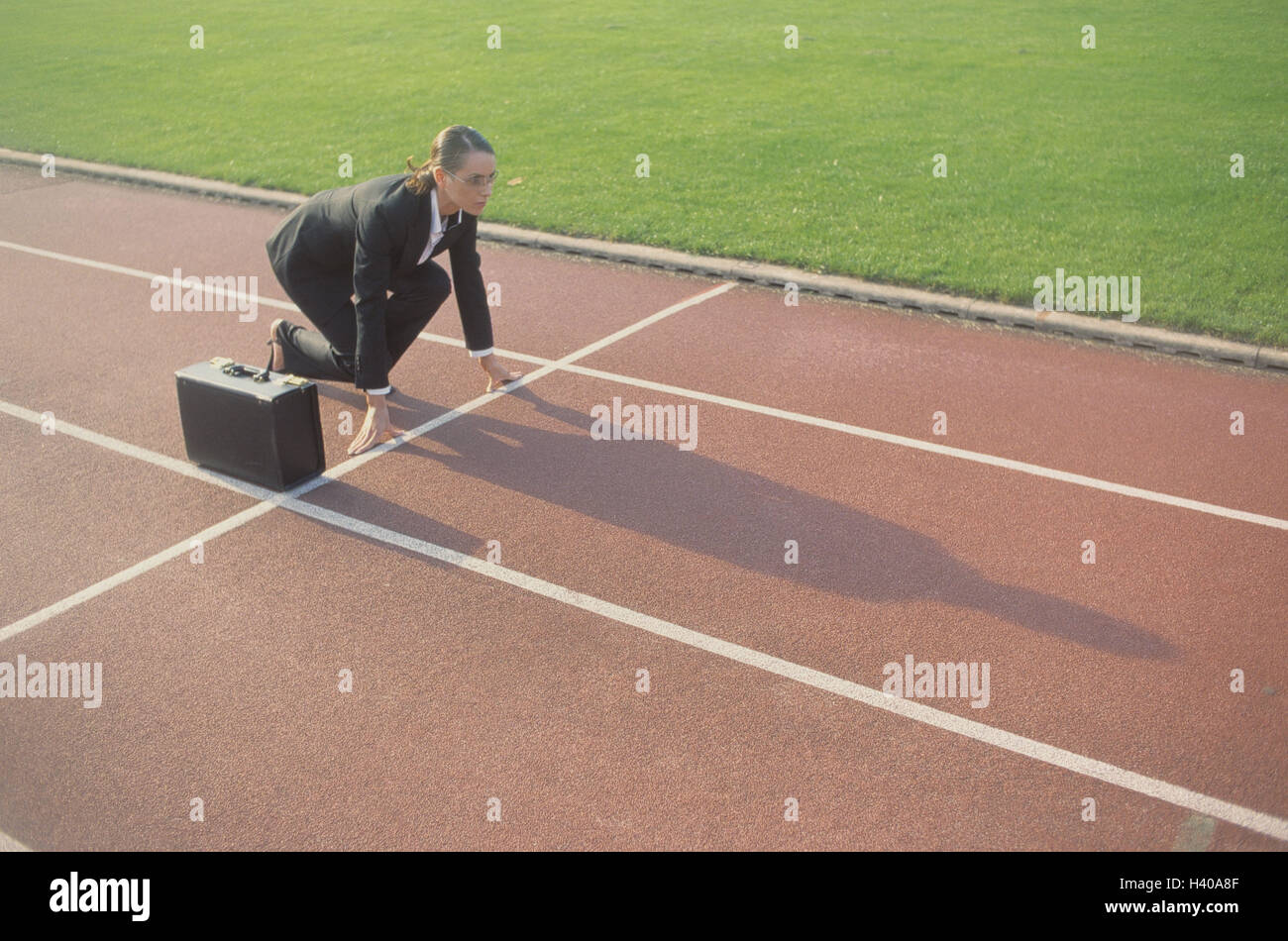 Dirt track, businesswoman, start position, briefcase, evening light, occupation, business, Tartanbahn, woman, manager, suit, career woman, briefcase, glasses, start, race, way to the success, ready for launch, ambitiously, energetically, purposefully, fut Stock Photo