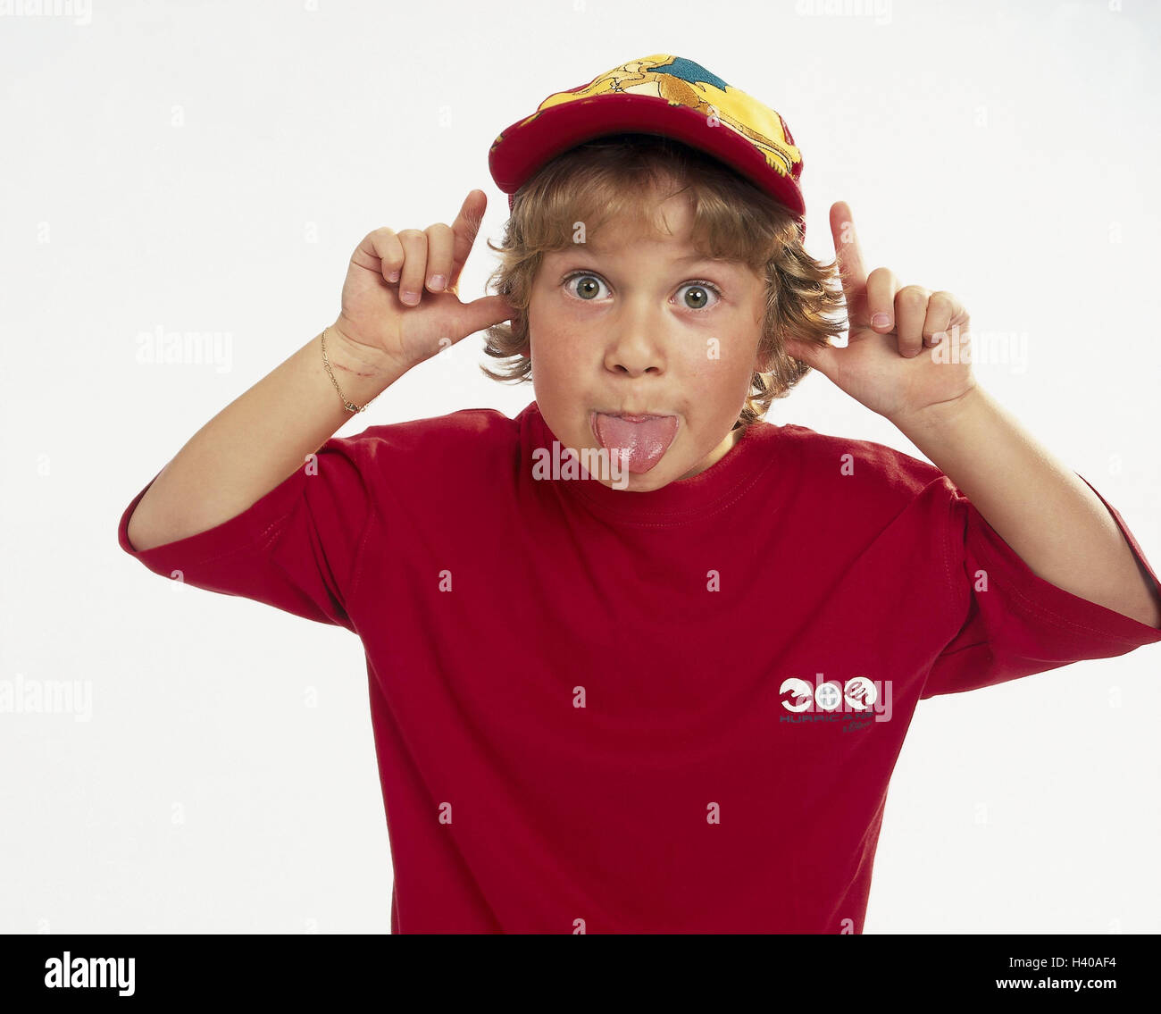 Boy, gesture, cheeky, tongue, stick out, half portrait, children, studio, cut outs, naughtily, impertinently, child, rebelliously, annoy, grimace, cap, rascal Stock Photo