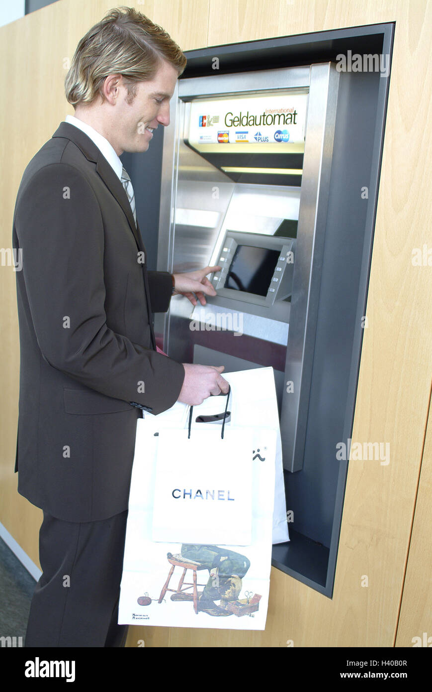 Bank, man, suit, bancomat, carrier bags, noble marks, business, economy, consumption, credit institute, high-speed train machine, cash dispenser, automatic cash dispenser, businessman, customer, bank customer, young, elegantly, account holder, keyboard, a Stock Photo
