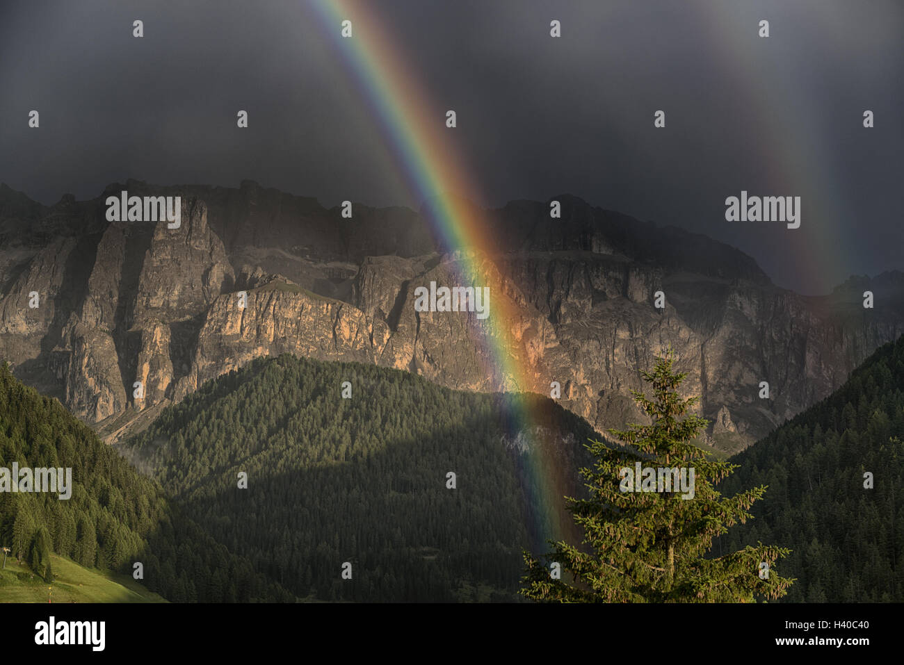 Rainbow after the thunderstorm over the hills and mountains of Selva di Val Gardena in a summer day, Trentino-Alto Adige Stock Photo