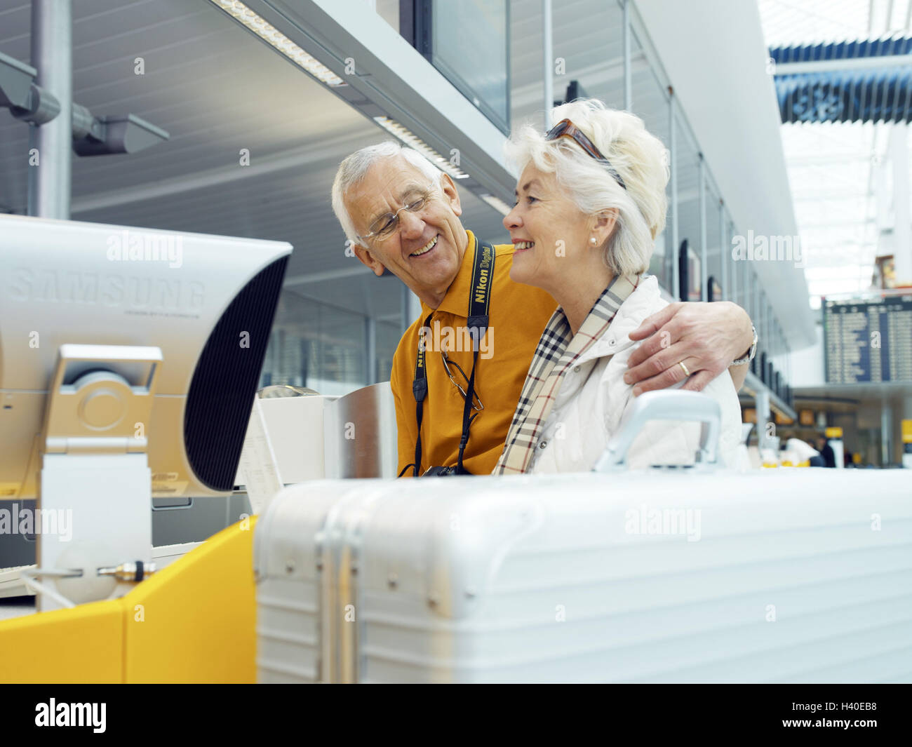 Airport, switch, Senior couple, check in, hand in, happy, check in, staff, man, ground crew, couple, senior citizens, passengers, airline passengers, luggage sale, luggage assignment, luggage, luggage, suitcase, pass, to travel, journey by air, foreign tr Stock Photo