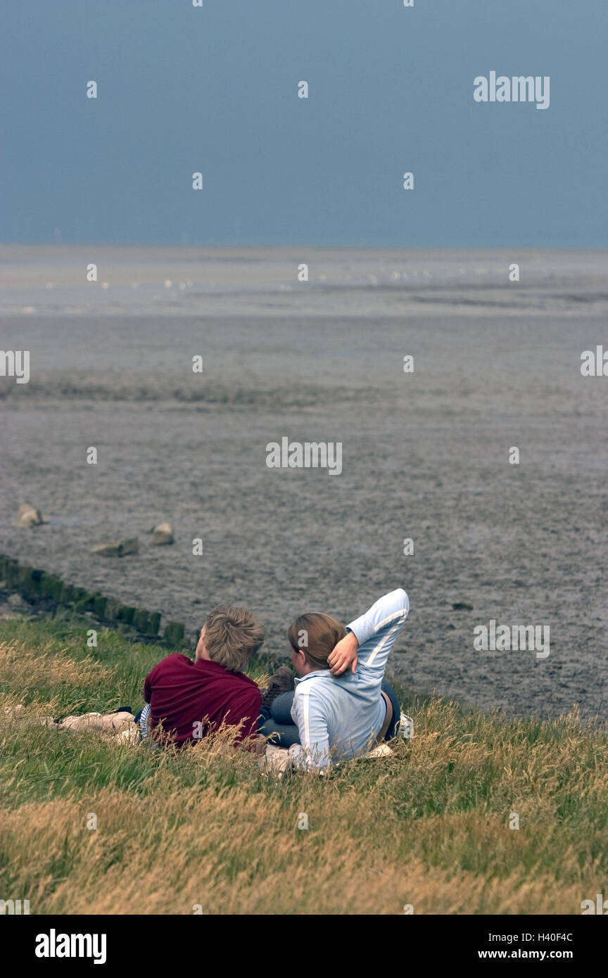 Coastal scenery, couple, lie, rest meadow, picnic, sea view, recreation, back view, autumn, partnership, respect, coast, grass, rest, take it easy, enjoy, together, fallen in love, leisure time, vacation, remotely, rest, silence, loneliness, view, sea, wi Stock Photo