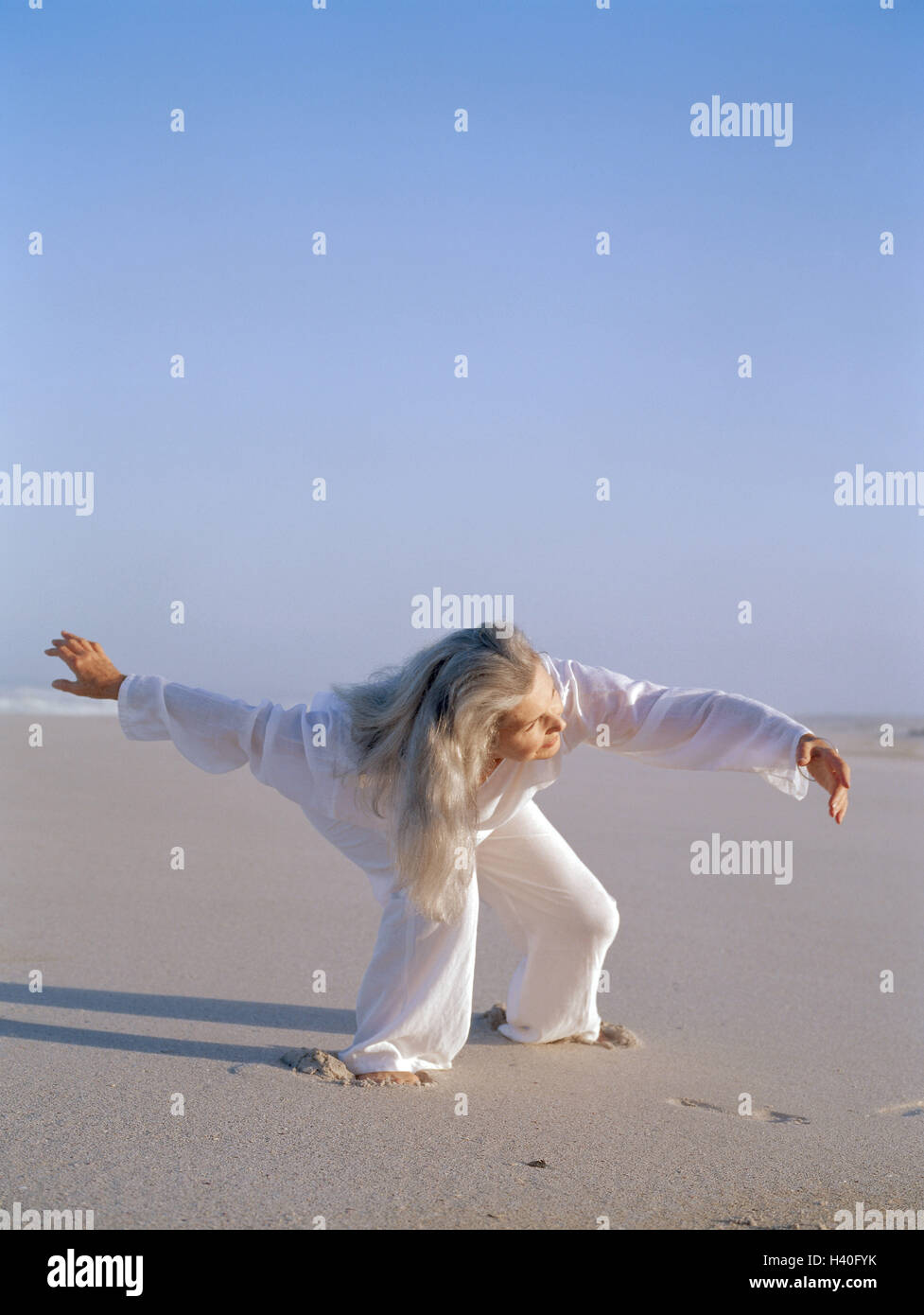 Sandy beach, woman, Tai-Chi, Best Age, 50-60 years, beach, sea, leisure time, hobby, practise, meditative, motion, motion sequences, exercises, slowly, fluently, shadow speakers, 'Free Flow Movement', balance, activity, body consciousness, meditation, Tai Stock Photo