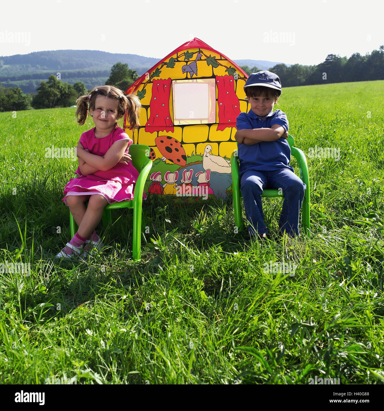 Meadow, children-game house, children, sit, chairs, arms, crosses, 4 years, siblings, boy, girl, friends, sulk, play fight, difference, distance, distance, childhood, tent, house, brightly, colourfully, icon, own home, security, security, Eigenheim-Kredit Stock Photo