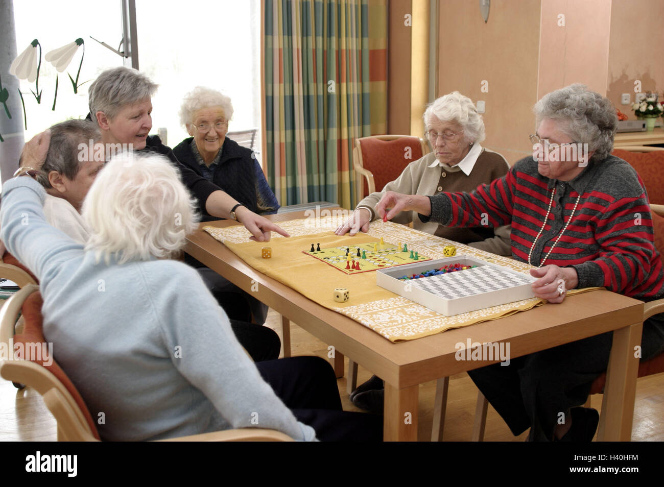 Old people's home, seniors, parlour game, old people's home, nursing home, senior citizen's home, retirement home, day room, women, senior citizens, board game, game, Mensch-ärgere-Dich-nicht, play, pastime, activity, leisure time, amusement, together, en Stock Photo