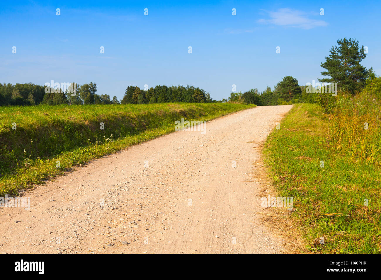 Turning empty rural road perspective in bright summer day Stock Photo