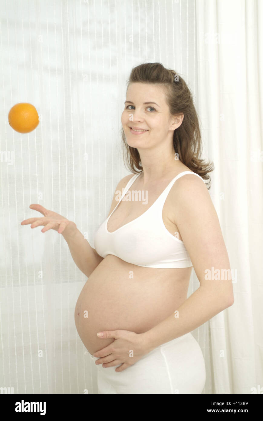 Woman, pregnant, bare midriff, orange, highlevel throwing, view camera