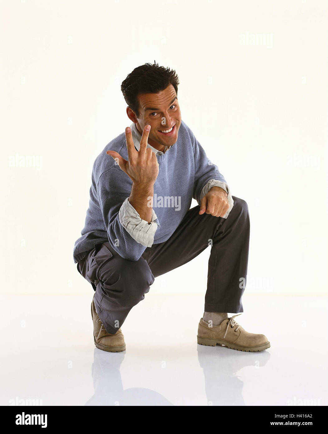 Man, young, squat, gesture, number, three, point, Men, cut outs, studio, smile, near, indicate, body language, count, enumerate, number, Stock Photo