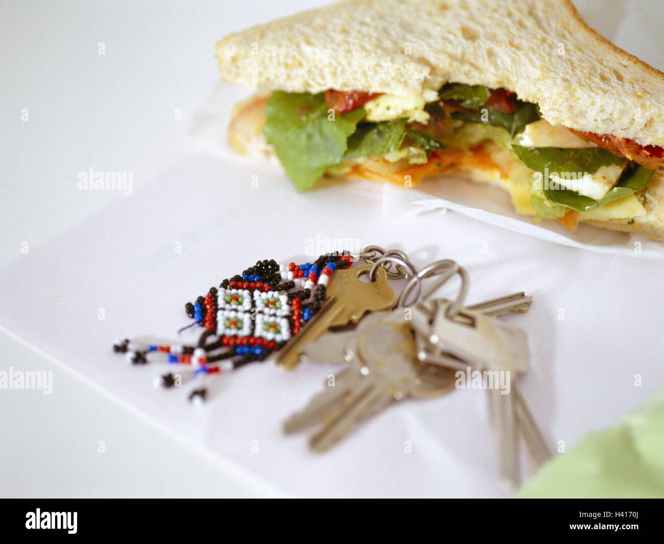 Table, sandwich, bitten into, key bundle, white bread, toast bread, bread, books, intermeal, hunger, appetite, eat, occasionally, break, nutrition, key, many, key fob, Still life, product photography Stock Photo