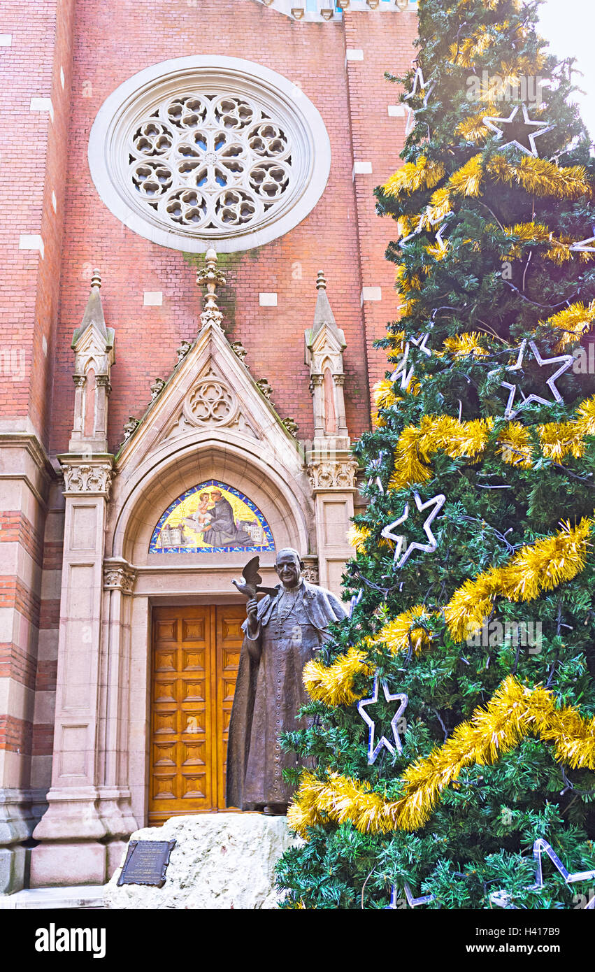 The statue of Pope John XXIII, behind the Christmas tree,, in the courtyard of St Antony's church, Istanbul, Turkey. Stock Photo