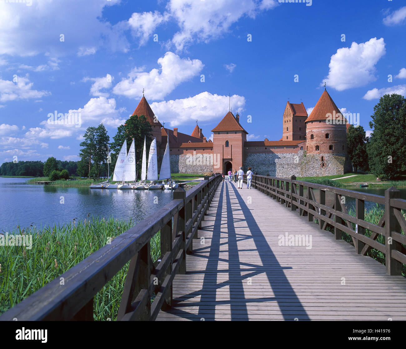 Lithuania, quay Tra, Galve Su, island castle, bridge, visitor, landing stage, sailboats, Europe, Nordosteuropa, the Baltic States, Lietuva, Lietuvos Respublika, Galvesee, Galve lake, island, castle, castle grounds, military plant, structure, architecture, place of interest, tourism, back view, wooden jetty, connection bridge, lake, sailboats, heavens, clouds Stock Photo