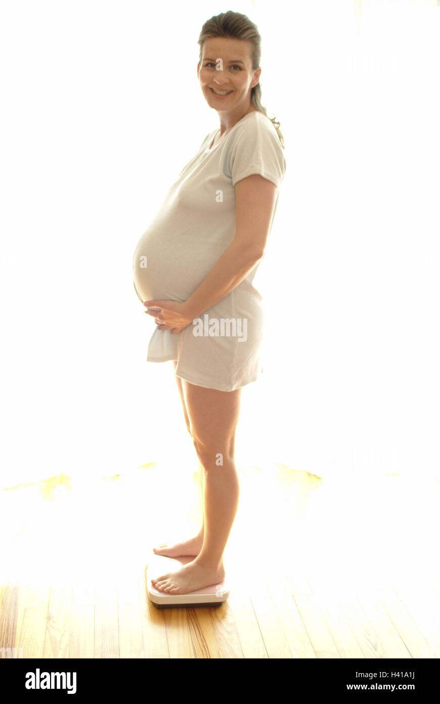 Woman, pregnant, body scales, weight controls, side view, Gestation, gestation, 25 - 35 years, pregnant, gestation, baby abdomen, scales, weight, body weight, weigh, controls, increase in weight, change, naturalness, smile, joy, happy, prejoy, child wish, Stock Photo