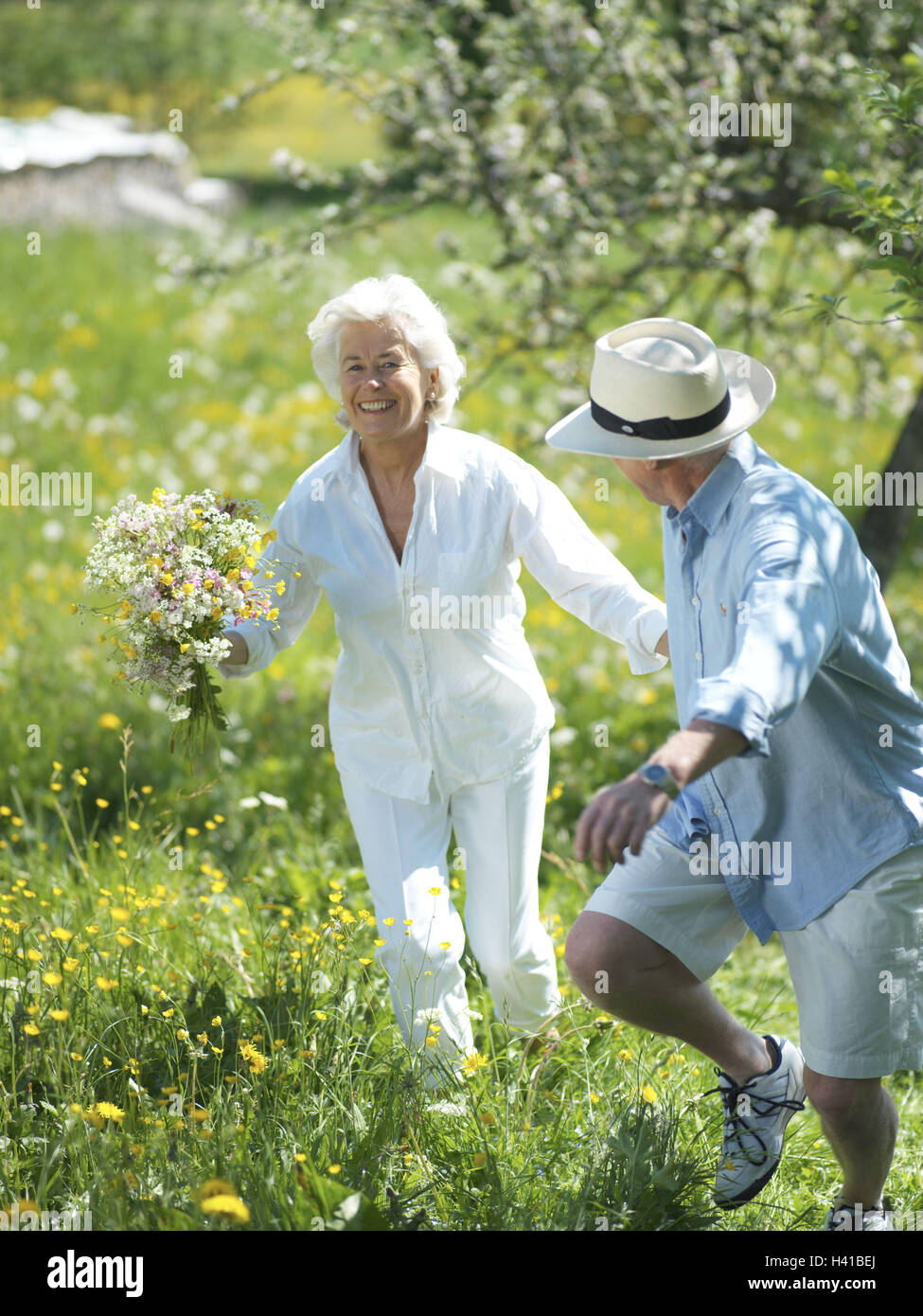 Senior couple, happy, run, hands hold, bouquet, meadow, summer excursion, vacation, summer vacation, retirement, pension, leisure time, recreation, rest, enjoy, Best Age, old person, senior citizens, couple, happy, contently, exhilarates, melted, enthusia Stock Photo