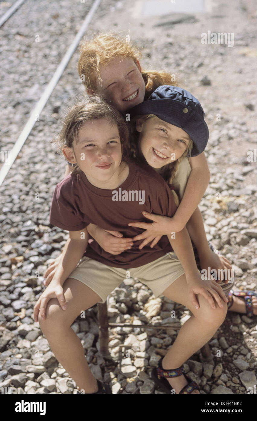 Railroad tracks, stools, girls, sit, embrace embrace, outside, summer, vacation, holidays, leisure time, childhood, children, 7 - 9 years, fun, happy, there, smile, affection, expression, friends Stock Photo