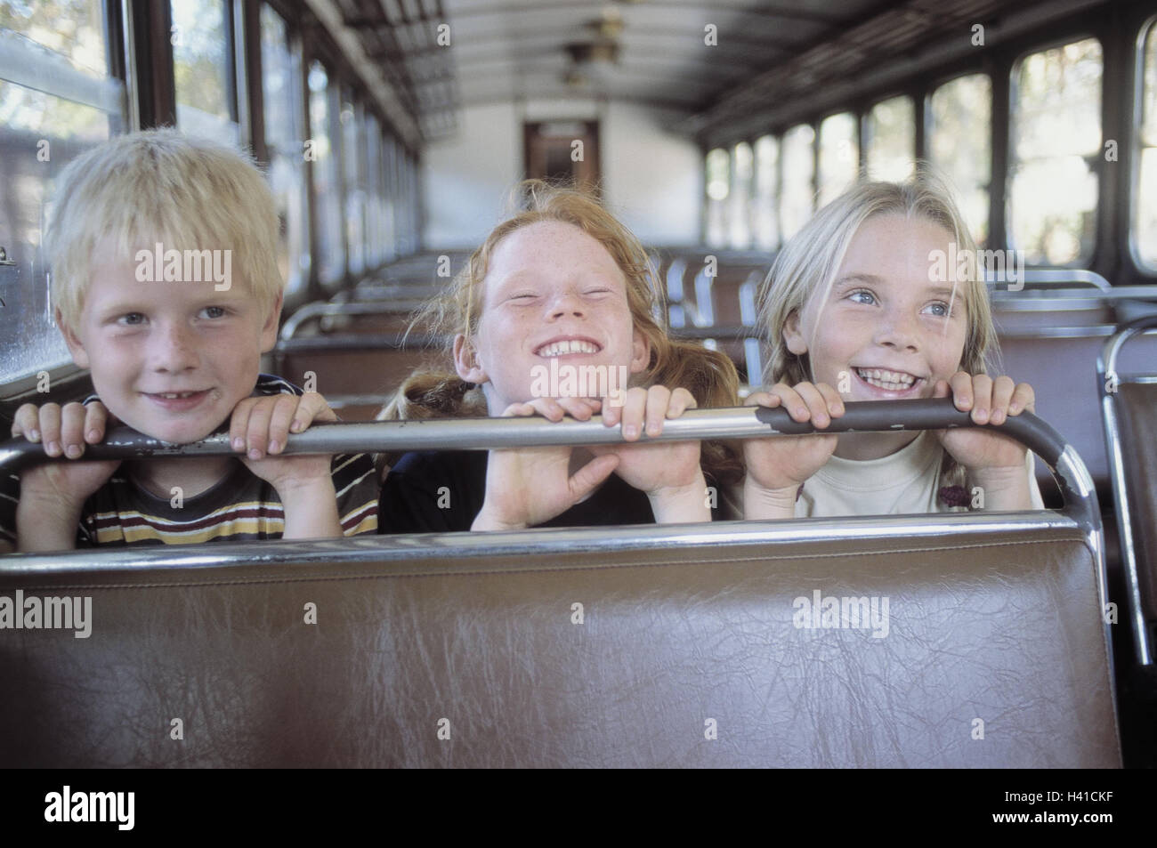Train compartment, girl, boy, happy, sit, fun, summer, vacation, holidays, leisure time, childhood, children, 7-9 years, friends, Geschwiste, excursion, travel, train travel, train journey, trajectory, railway car, carriage, old, laugh, amuse funnily, joy Stock Photo