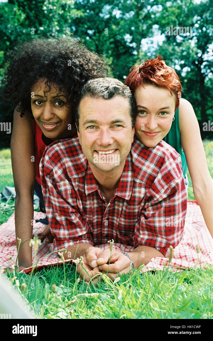 Man, women, skin colour, differently, meadow, lie, enjoy, happy, friends, clique, friendship, summer, outside, caps, leisure time, recreation, rest, relax, smile lighthearted, happily, Stock Photo