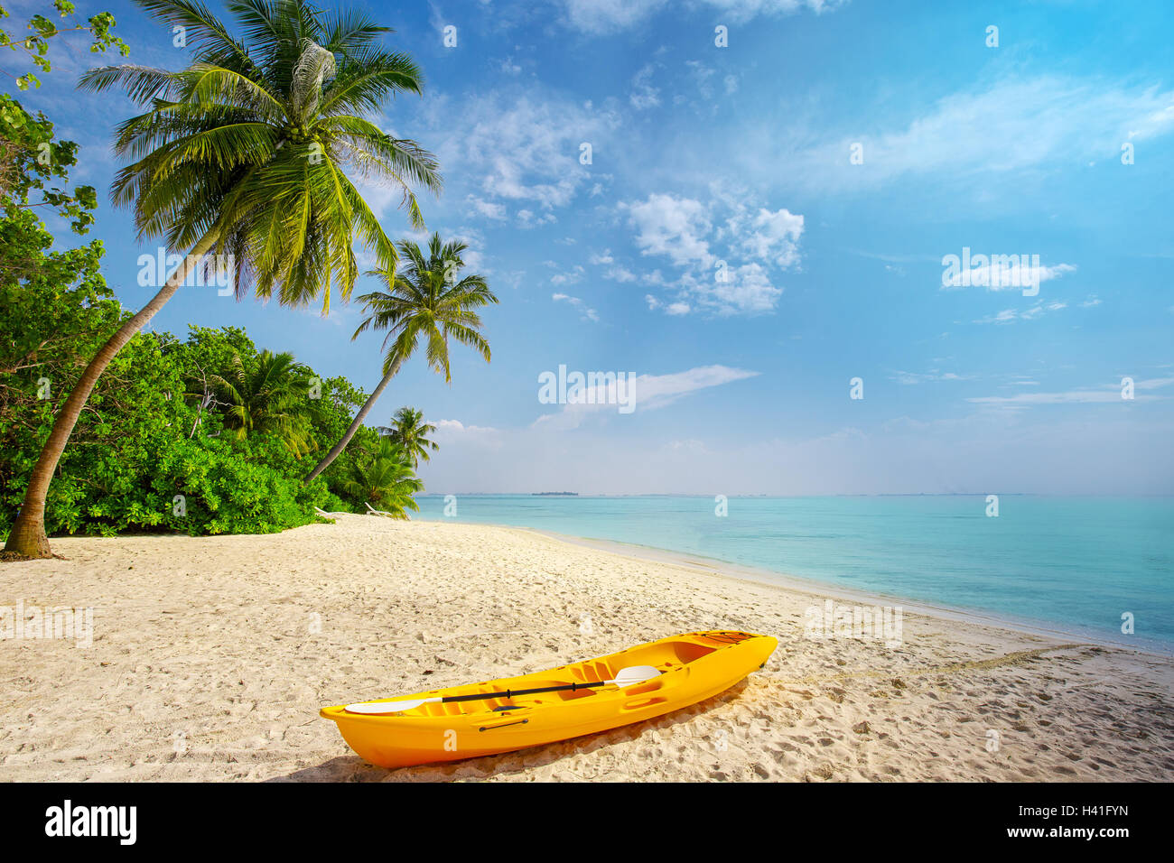 Kayak on sunny tropical beach with palm trees on Maldives Stock Photo