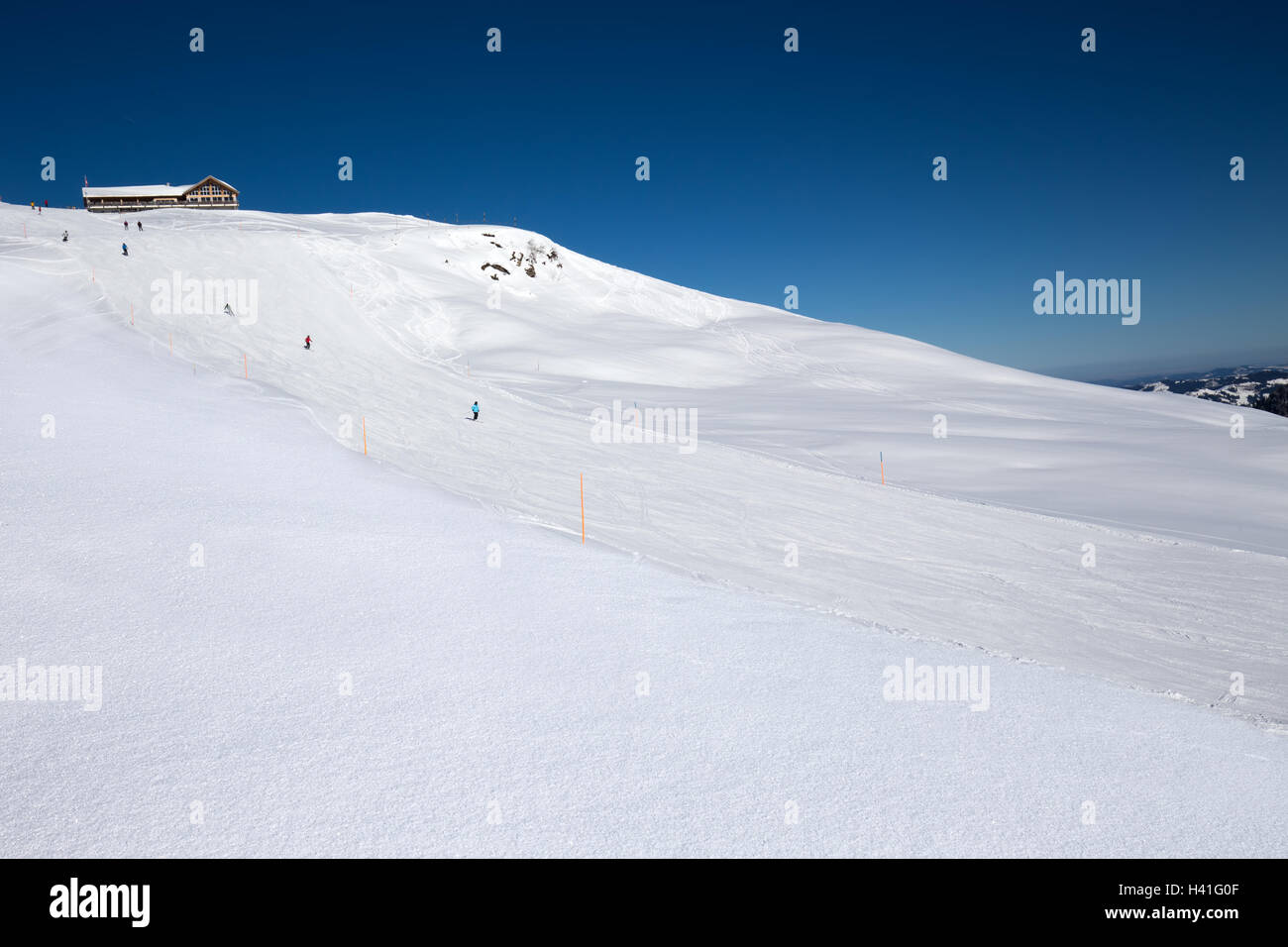 Skiers on the slope from the Spirstock peak in Hoch-Ybrig ski resort, Swiss Alps, Schwyz, Central Switzerland Stock Photo