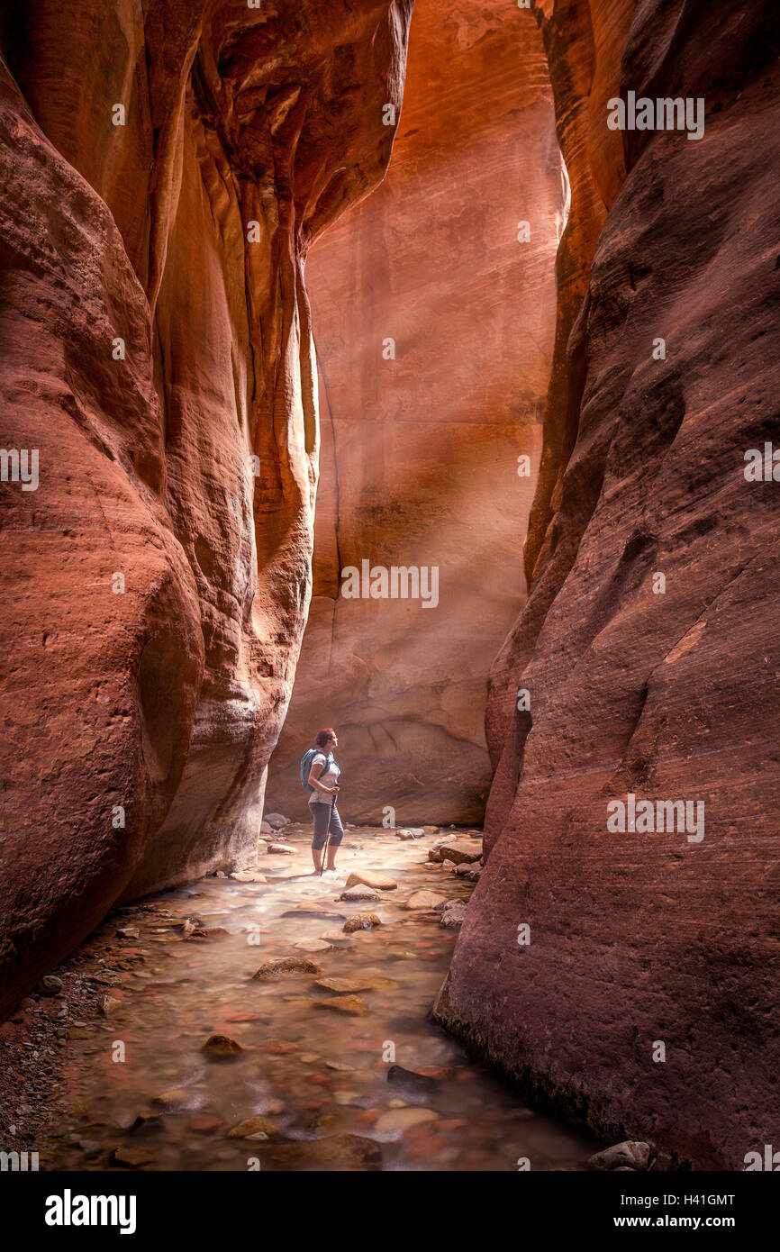 Woman standing in red slot canyon, Utah, United States Stock Photo