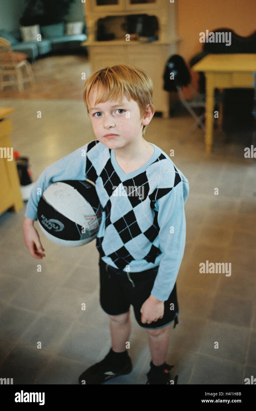 Sitting rooms, boy, ball, seriously, flat, child, 7 years, inside, stand, football, basketball, expression, sadly, only, lonely, unhappily, boredom, undecided, very close Stock Photo